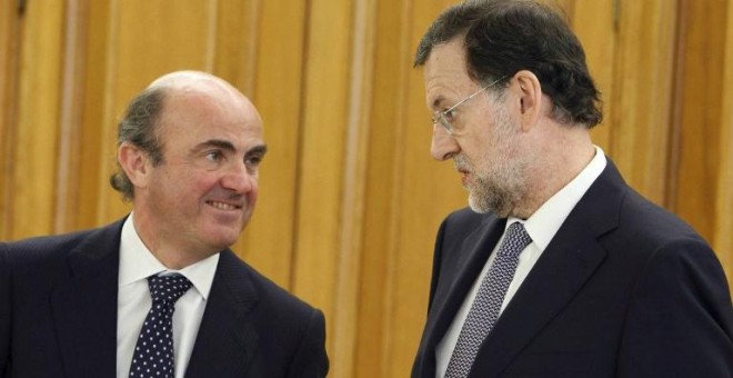 El ministro de Economía, Luis de Guindos, y el presidente del Gobierno, Mariano Rajoy, en una foto de junio de 2011 en el Palacio de la Zarzuela, en la jura del cargo del gobernador del Banco de España Luis Maria Linde.AFP