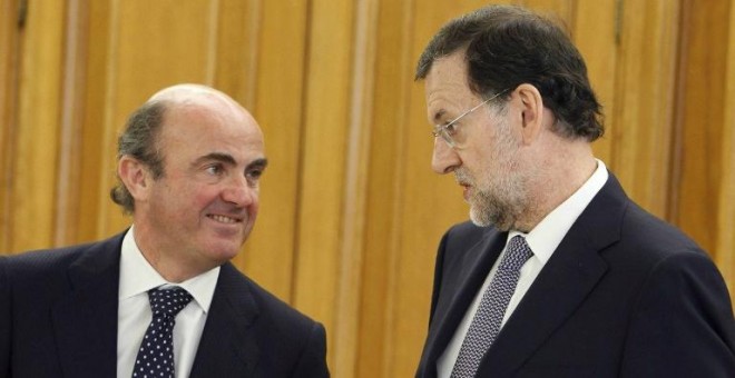 El ministro de Economía, Luis de Guindos, y el presidente del Gobierno, Mariano Rajoy, en una foto de junio de 2011 en el Palacio de la Zarzuela, en la jura del cargo del gobernador del Banco de España Luis Maria Linde.AFP