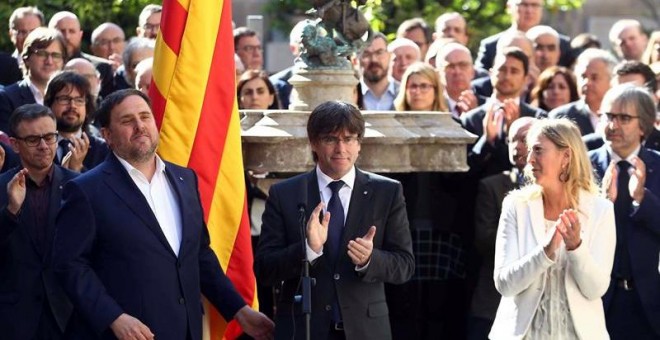 El presidente de la Generalitat, Carles Puigdemont (c), y la consellera de Presidencia, Neus Munté (d), aplauden al vicepresidente, Oriol Junqueras, tras su intervención en el acto organizado por el gobierno catalán para solemnizar y escenificar el compro