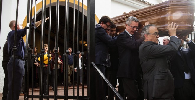 El exministro de Justicia, Alberto Ruiz Gallardón, yerno del fallecido José Utrera Molina porta junto a otros allegados el féretro del que fuera ministro en la época franquista, mientras os asistentes cantan el 'Cara al Sol', en la Iglesia de San Miguel e