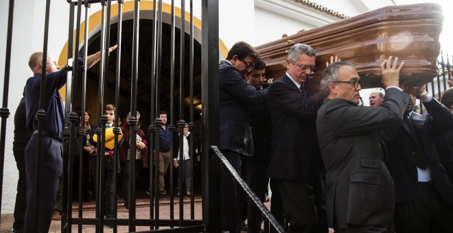 El exministro de Justicia, Alberto Ruiz Gallardón, yerno del fallecido José Utrera Molina porta junto a otros allegados el féretro del que fuera ministro en la época franquista, mientras os asistentes cantan el 'Cara al Sol', en la Iglesia de San Miguel e