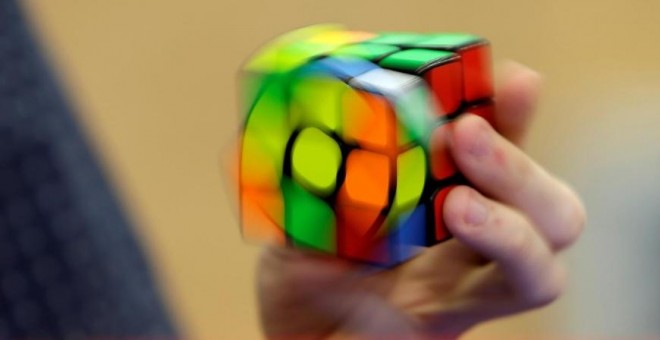 Una persona resuelve un cubo de Rubik con una mano. REUTERS