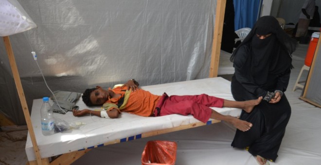 Una mujer se sienta junto a su hijo enfermo de cólera en un hospital de la ciudad de Hodeidah, Yemen.- REUTERS / Abduljabbar Zeyad