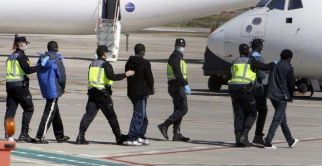 La Policía traslada hasta el avión a un grupo de inmigrantes que va a deportar desde Melilla.- EFE / ARCHIVO