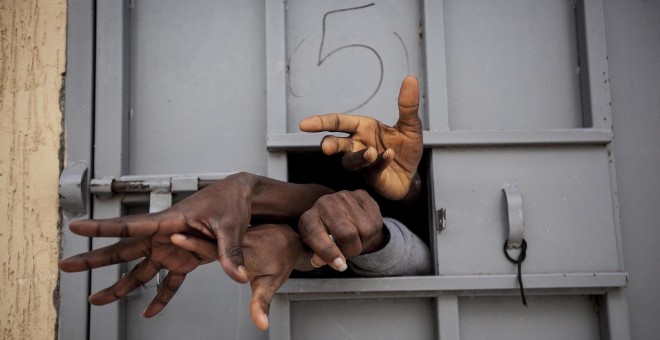Siete migrantes subsaharianos sacan las manos por la ventana de una celdaen el Centro de Detención de Garabuli, suplicando agua, cigarros, comida y su liberación /Narciso Contreras