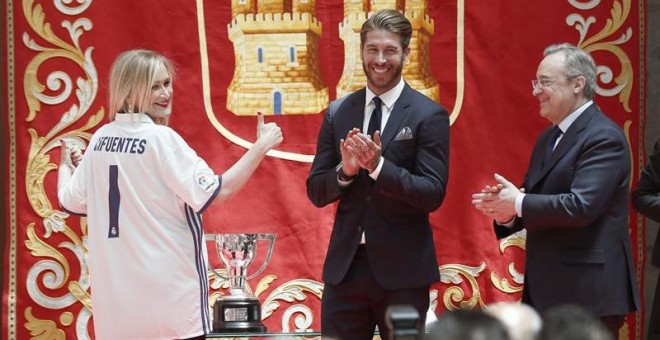 La presidenta de la Comunidad de Madrid, Cristina Cifuentes, posa con la camiseta del Real Madrid que le han entregado el capitán del Real Madrid, Sergio Ramos (2d), y el presidente del Club, Florentino Pérez (d). /EFE