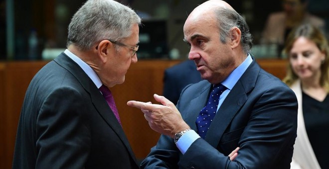 El director del Mecanismo de Estabilidad Europeo (MEDE),  Klaus Regling, conversa con el ministro de Economía, Luis de Guindos, antes del comienzo de una reunión de Ecofin en  Bruselas. AFP/Emmanuel Dunand