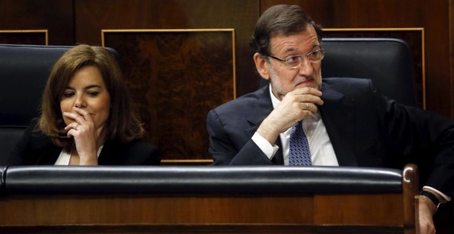 El presidente del Gobierno y del PP, Mariano Rajoy, junto a su número dos en el Ejecutivo, Soraya Sáenz de Santamaría, en sus escaños del Congreso. Archivo REUTERS