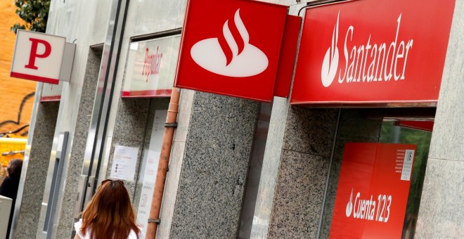 Una mujer pasa por delante de sendas sucursales de Banco Santander y Banco Popular en Barcelona. REUTERS/Albert Gea