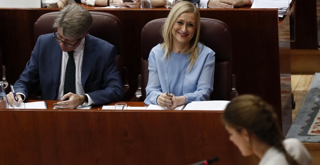 La presidenta de la Comunidad de Madrid, Cristina Cifuentes, junto a su portavoz y consejero de Presidencia y Justicia, Ángel Garrido, escucha la intervención de la portavoz de Podemos en el Parlamento regional, Lorena Ruiz-Huerta, durante el Pleno de la