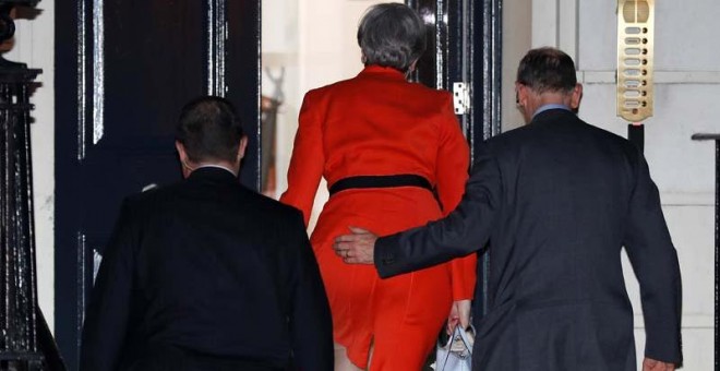 La primera ministra, Theresa May, llega a la sede del partido conservador en Londres acompañada por su marido. | PETER NICHOLS (REUTERS)