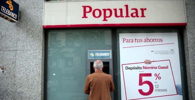 Un hombre retira dinero de un cajero de una sucursal del Banco Popular en Madrid. | EFE