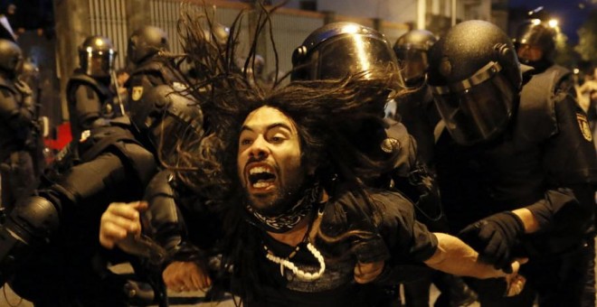 La policía desaloja a un manifestante del interior de un inmueble tras la manifestación por calles de Santiago de Compostela.- EFE