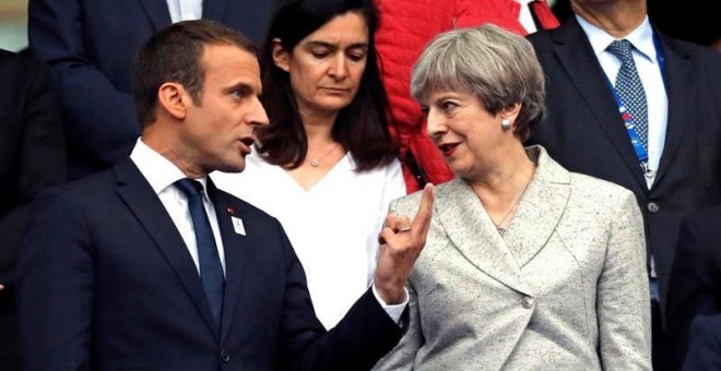 El presidente francés Emmanuel Macron (izda) y la primera ministra británica Theresa May asisten a un partido de fútbol amistoso entre las selecciones de ambos países en el estado Stade de France. /EFE