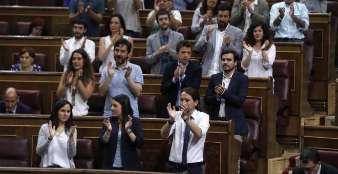 Los diputados de Podemos aplauden a uno de los suyos. | EFE