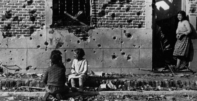 Robert Capa  Los niños juegan ajenos al horror de la guerra ante la fachada destrozada  por la metralla del número 10 de la calle Peironcely, November-December  1936  ©International Center of Photography/Magnum Photos