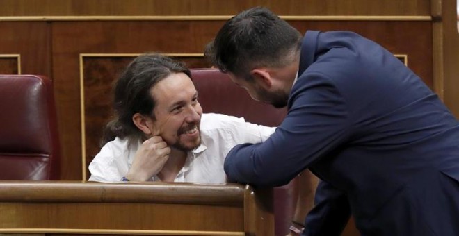 El secretario general de Podemos, Pablo Iglesias (i), conversa con el diputado de ERC Gabriel Rufián durante el pleno del Congreso que se celebra esta tarde. EFE/Chema Moya
