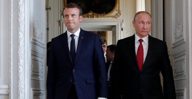 El presidente francés, Emmanuel Macron (i), y su homólogo ruso, Vladimir Putin (d), caminan por el Palacio de Versalles durante una reunión con motivo de una exposición que conmemora 300 años de relaciones diplomáticas entre ambos países REUTERS/Philippe
