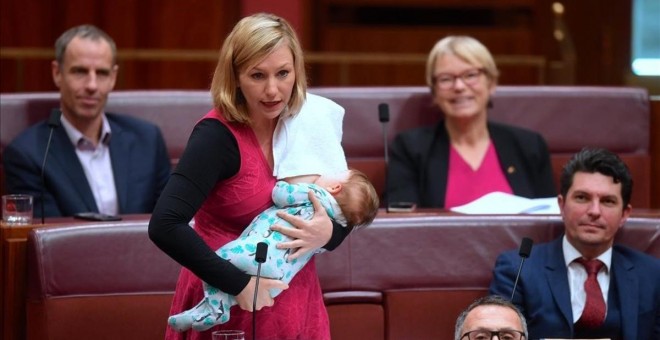 La senadora australiana Larissa Waters amamanta a su bebé mientras interviene en el parlamento. REUTERS