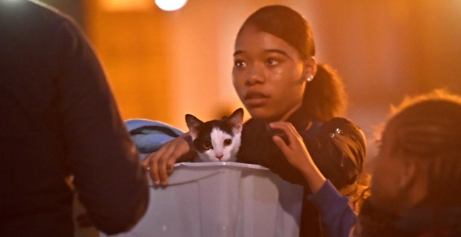 Una residente con su mascota en el momento de ser evacuada de su vivienda en el ediifcio Taplow Tower, en el barrio londinense de Camdem. REUTERS/Hannah McKay