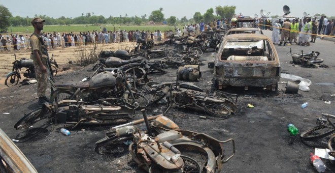 Coches y motocicletas carbonizados en la carretera de Pakistán donde un camión cisterna ha tenido un accidente y ha estallado, provocando más de 120 muertos. EFE / EPA / FAISAL KAREEM