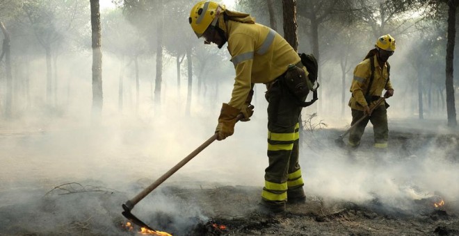 Bomberos trabajan en los alrededores de Mazagón, en Huelva, en el incendio que ha obligado a desalojar a más de 2.000 personas y que continúa acechando el Espacio Natural de Doñana. EFE/Julián Pérez