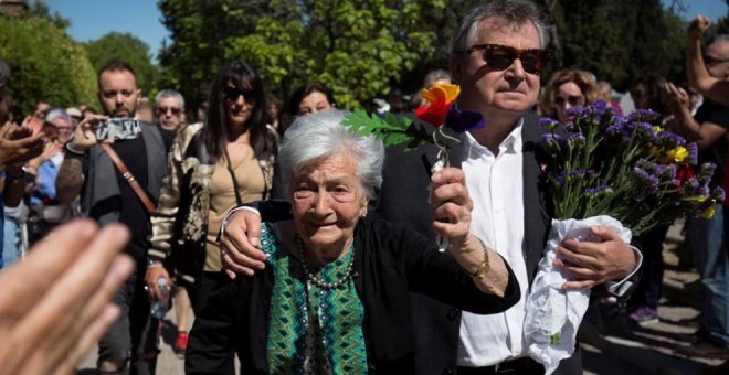 La lucha de una vida. Ascensión levanta unas flores con los colores republicanos junto a su hijo.- REUTERS