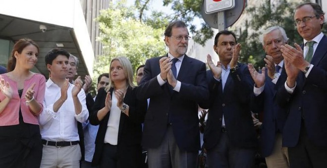 El presidente del Gobierno y del PP, Mariano Rajoy, junto a Marimar Blanco y otros dirigentes del PP en el despliegue de la pancarta en la sede del partido. | JUAN CARLOS HIDALGO (EFE)
