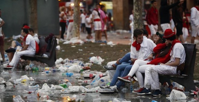 Jóvenes sentados en bancos en la Plaza del Castillo de Pamplona este domingo. /EFE