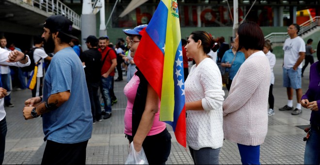 Una mujer con una bandera de Venezuela hace cola para votar en el Plebiscito (no oficial) contra el Gobierno de Nicolás Maduro.REUTERS/Andrés Martínez Casares