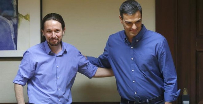 Los líderes de Podemos, Pablo Iglesias (i) y del PSOE, Pedro Sánchez, se saludan durante la reunión mantenida con sus equipos en el Congreso, en el inicio de las negociaciones para buscar acuerdos parlamentarios. /EFE