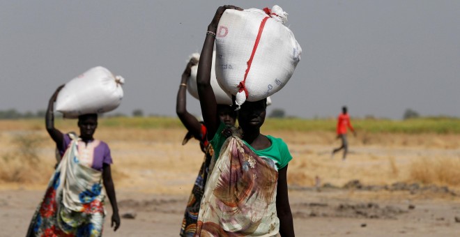 Varias mujeres llevan sacos de alimentos en el pueblo Nimini, en el estado de Unity, al norte de Sudán del Sur.- REUTERS / Siegfried Modola