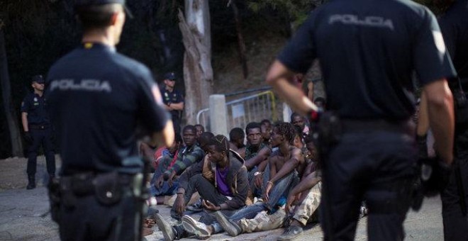 La Policía frente al grupo de migrantes después de saltar la valla de Ceuta / REUTERS