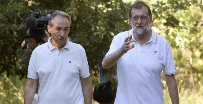 El presidente del Gobierno, Mariano Rajoy (d), acompañado por el presidente de la Autoridad Portuaria de Marín, José Benito Suárez (i), durante su paseo por las orillas del río Umia, en Ribadumia (Pontevedra). EFE/Salvador Sas