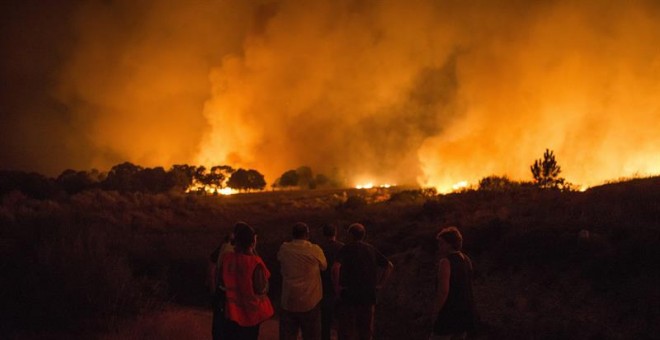 Vecinos de Devesa (Vilardevós) observan el incendio forestal declarado ayer por la tarde en el municipio de Verín que obligó a activar la alerta por 'situación 2' por proximidad a núcleos poblados y a cortar carreteras (la N-525 y la A-52). EFE/Brais Lore