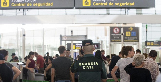 Un agente de la Guardia Civil en un control de seguridad del Aeropuerto de Barcelona-El Prat, donde se han vuelto a registrar colas de hasta una hora. EFE/Quique García