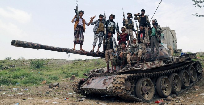 Miembros de las milicias pro-gubernamentales de Yemen, subidos sobre un carro de combate cerca de una zona de combates contra los rebeldes hutíes, en la ciudad de Taiz, al suroeste del país. REUTERS/Stringer