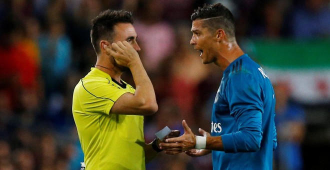 El jugador del Real Madrid Cristiano Ronaldo protesta ante el árbitro Ricardo de Burgos Bengoetxea por su expulsión en el partido de ida de la Supercopa de España en el Nou Camp. REUTERS/Juan Medina