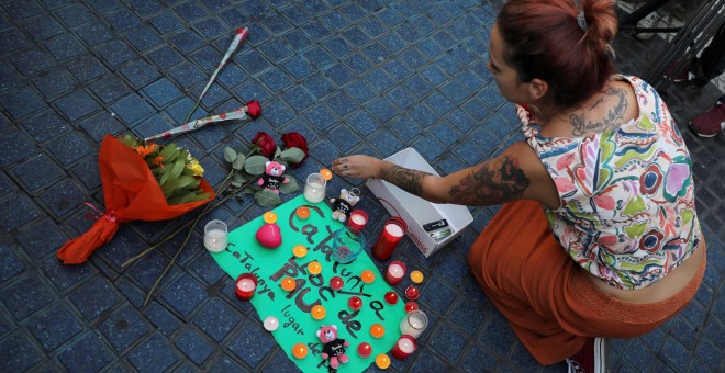 Una mujer coloca velas y un cartel que reza: 'Catalunya, lugar de paz' en la zona del atentado REUTERS/Sergio Perez