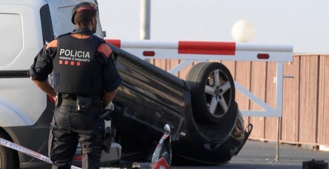 Un agente, junto al coche que usaron los terroristas en su ataque en Cambrils. - AFP