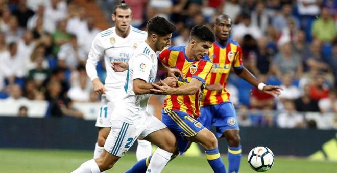 El delantero del Real Madrid Marco Asensio lucha el balón con Carlos Soler, del Valencia CF. - EFE