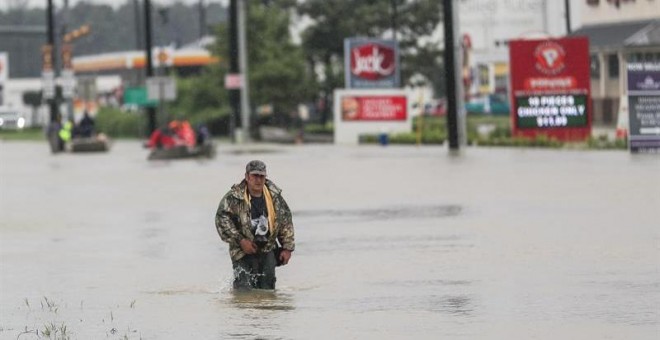 Un hombre camina por una calle inundada después del paso del huracán Harvey en Houston, Texas. - EFE