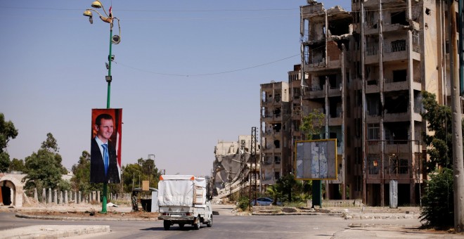 Un cartel del presidente sirio Bashar al-Assad en el distrito de Waer en la ciudad siria central de Homs, Siria / Omar Sanadiki - REUTERS