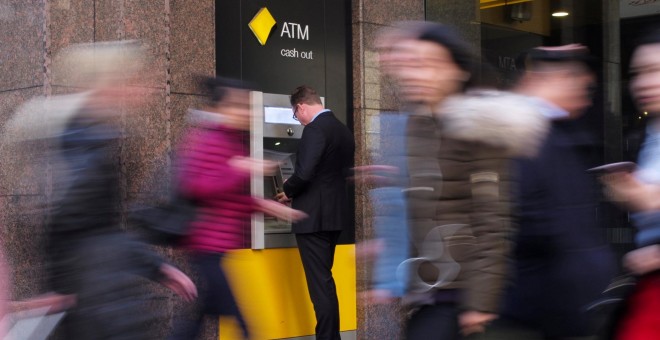 Un hombre saca opera en un cajero automático del banco austaliano Commonwealth Bank, en Sydney. REUTERS/Jason Reed