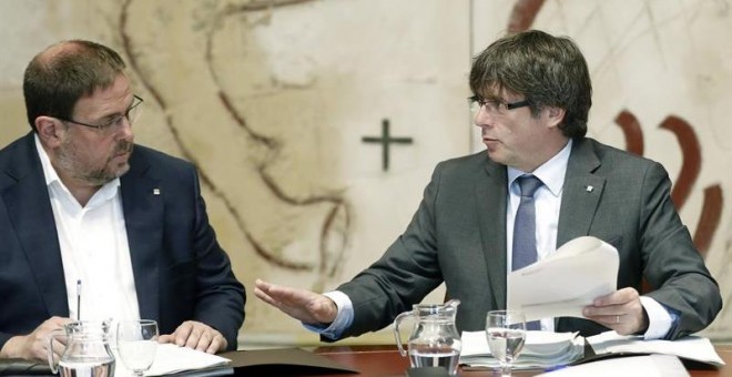 El presidente de la Generalitat, Carles Puigdemont, y el vicepresidente del Govern, Oriol Junqueras (i), hoy durante la reunión semanal del Govern, un día después de presentarse la futura ley de Transitoriedad Jurídica, que marca el camino del pulso seces