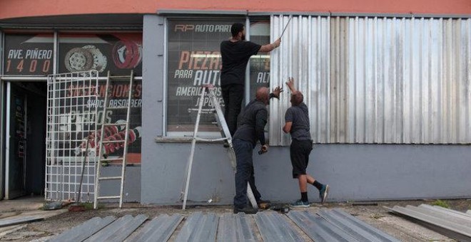 Hombres cubren las ventanas de una tienda de recambios para prepararse para el huracán 'Irma' en San Juan, Puerto Rico / REUTERS - Alvin Baez
