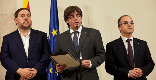 El president de la Generalitat, Carles Puigdemont, acompañado por el vicepresidente Oriol Junqueras y el conseller de presidencia Jordi Turull. - EFE