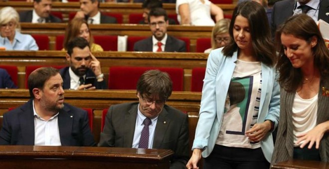 El presidente de la Generalitat de Cataluña, Carles Puigdemont (c) y el vicpresidente del Govern, Oriol Junqueras (i) y la presidenta del grupo parlamentario de Ciudadanos, Inés Arrimadas (2d), momentos antes de abandonar hoy el hemiciclo del Parlament de