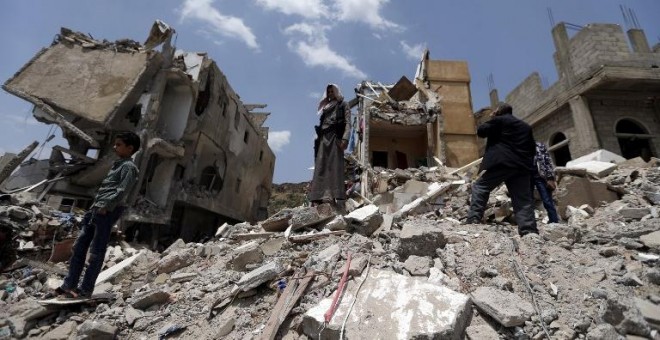 Varios yemeníes sobre las ruinas de un edificio de la capital del país, Sanaa, derruido por los bombardeos. APF/Mohammed Huwais