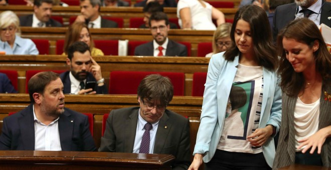 Las diputadas Inés Arrimadas, de Ciudadanos, y Andrea Levy, del PP, pasan junto a los escaños del president de la Generalitat, Carles Puigdemont, y del vicpresidente, Oriol Junqueras, en Parlament de Catalunya. EFE/Toni Albir